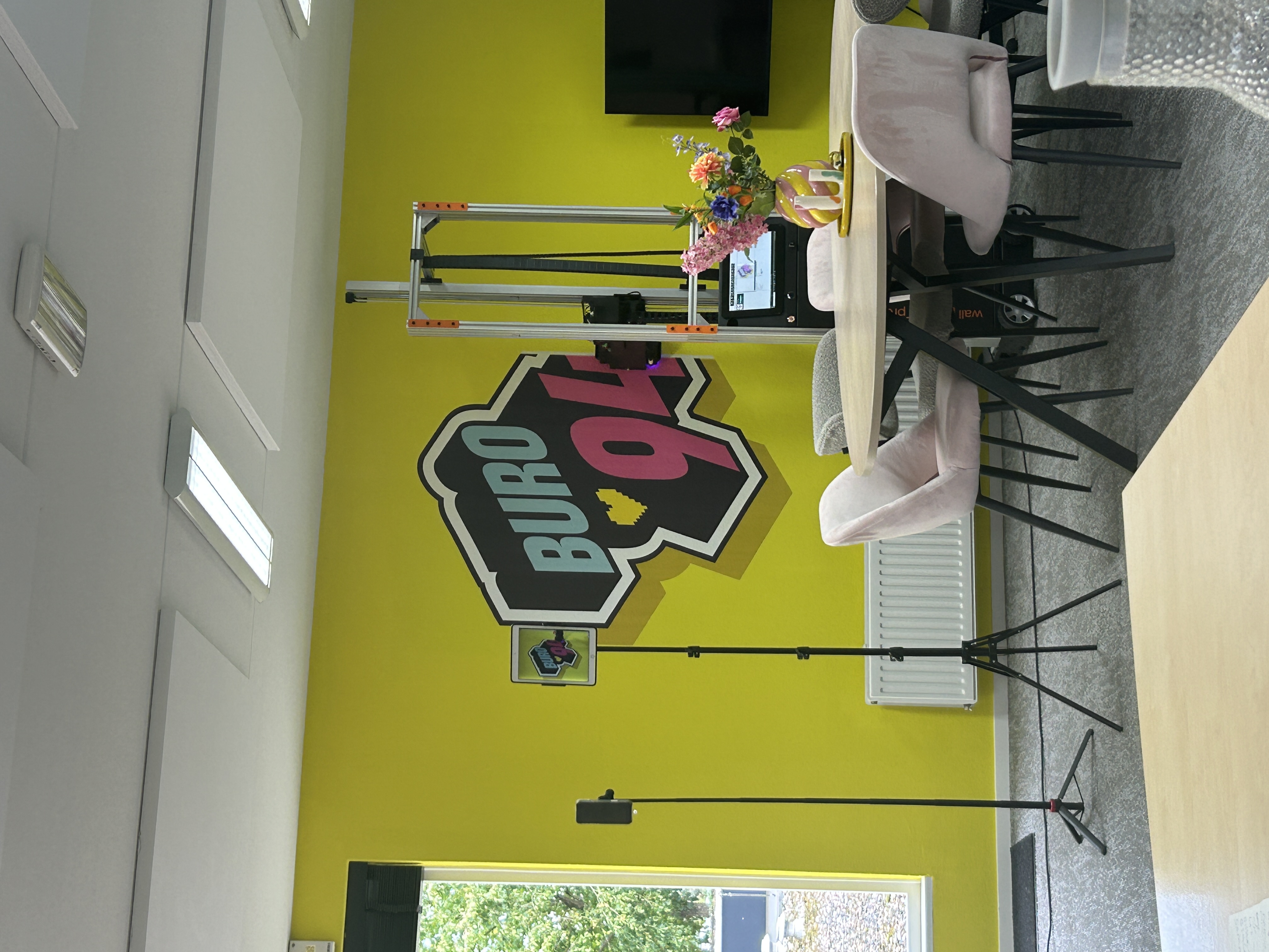 Geprint logo van Buro94 op een gele kantoorwand, uitgevoerd als zakelijke muurprint met diepte-effect op een structuurmuur.
