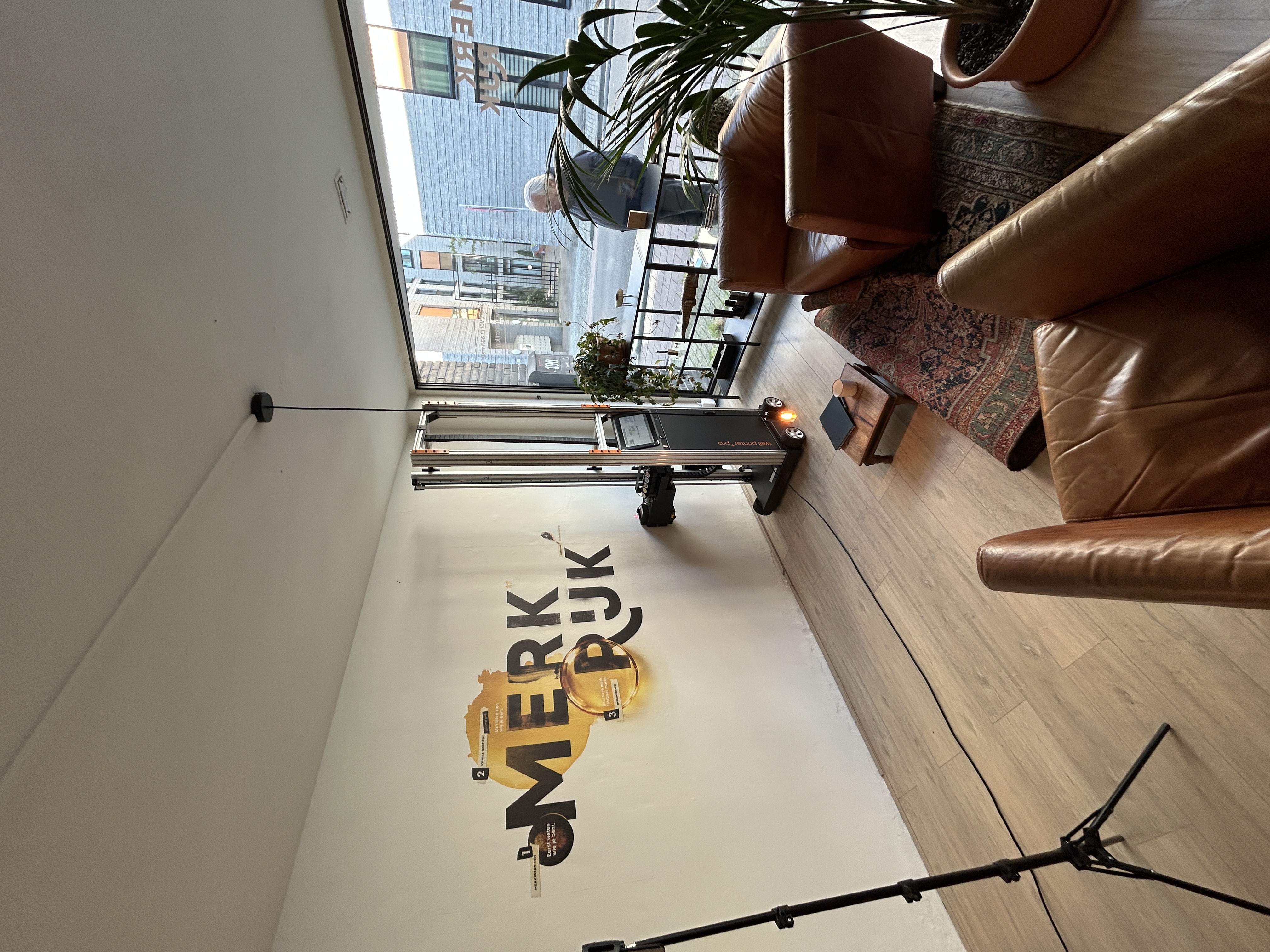 Muurprint op locatie voor Merkrijk, waarbij het eigen ontwerp van het bedrijf haarscherp op de studiowand is geplaatst.
