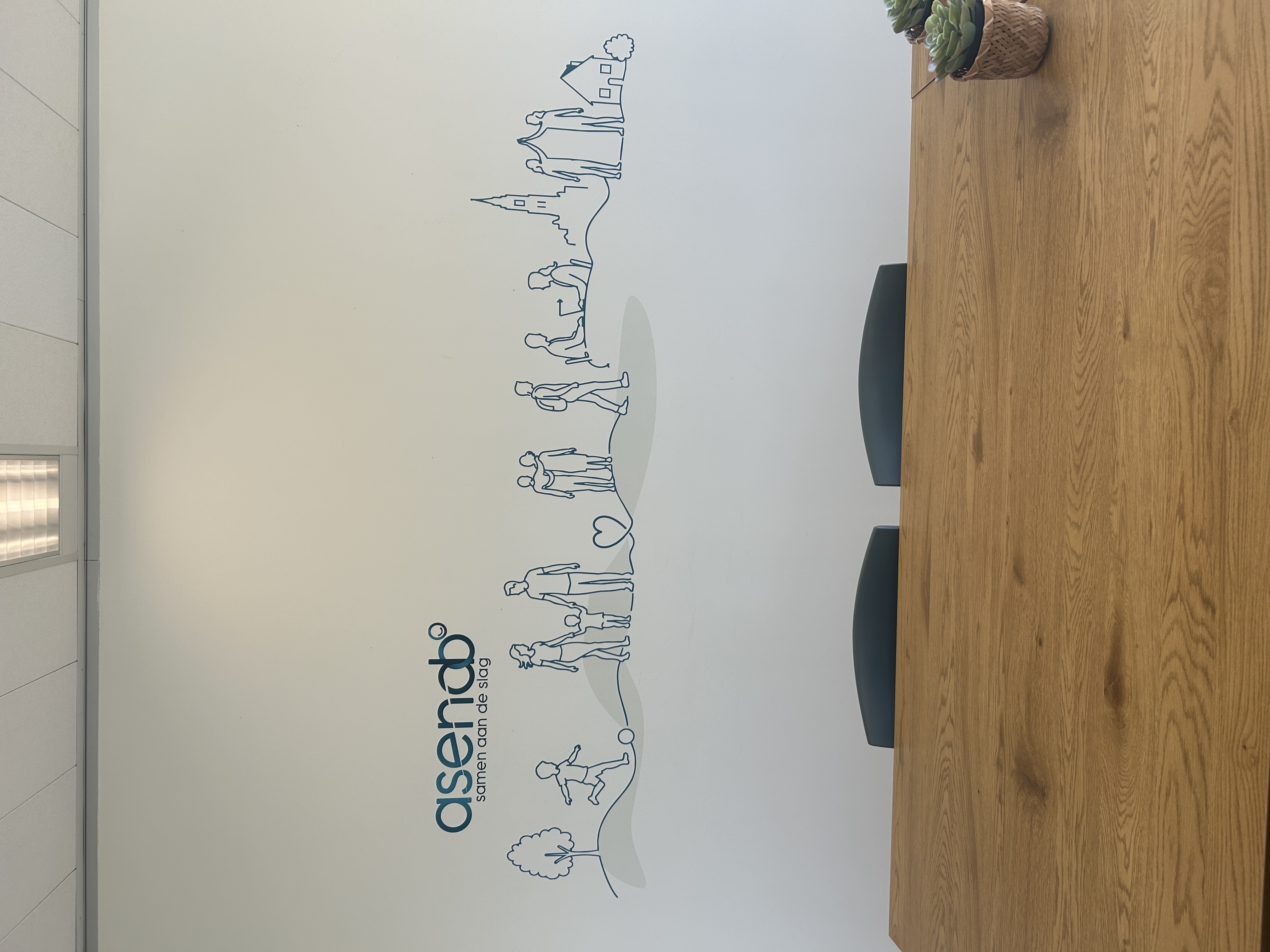 Muurprint op locatie met de missie van Asendo als minimalistische lijntekening, haarscherp geprint op een kantoorwand in Tilburg.