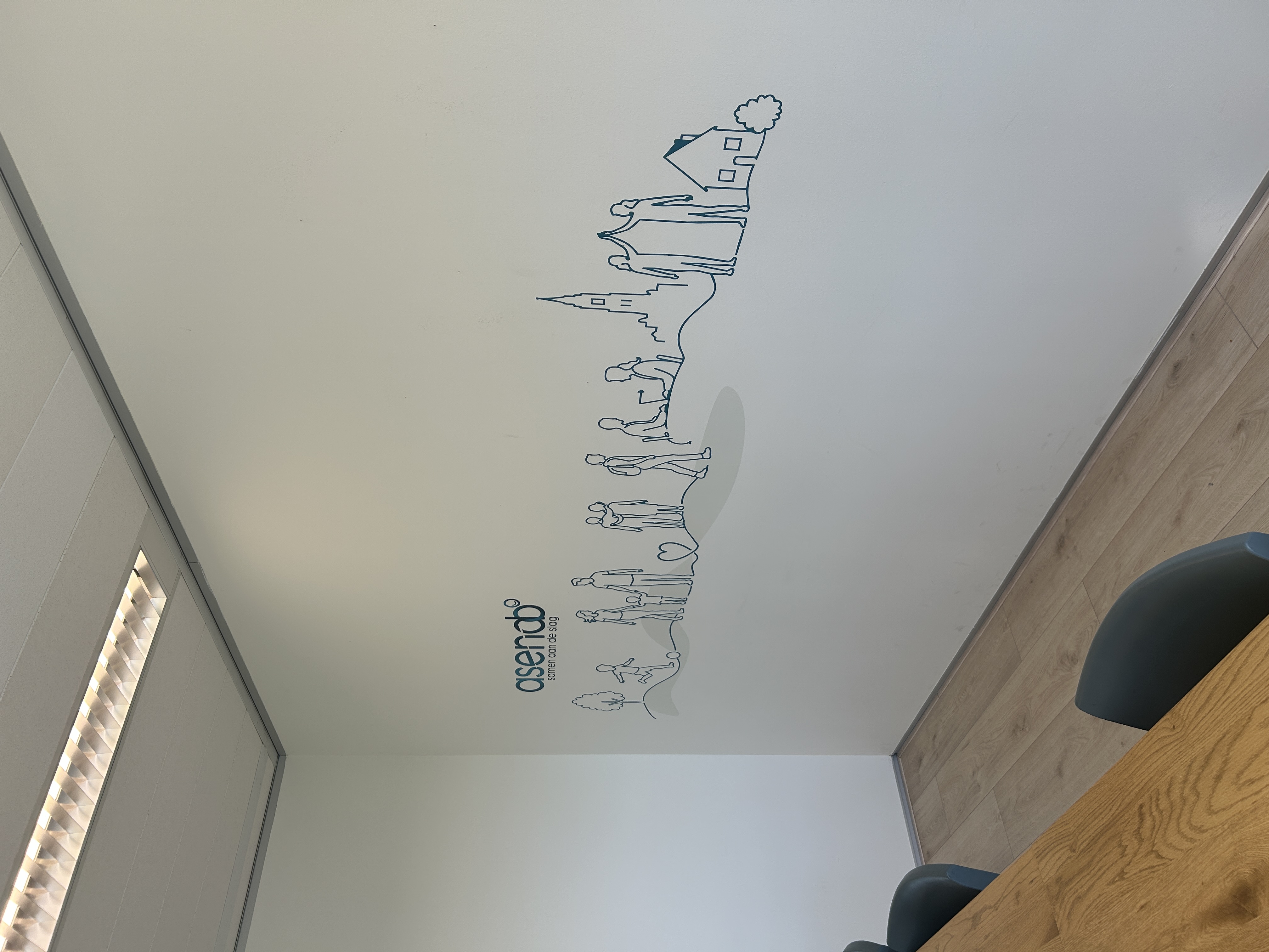 Minimalistische missie-muurprint voor Asendo in Tilburg, als strakke lijntekening direct op de muur geprint in een gezamenlijke kantoorruimte.